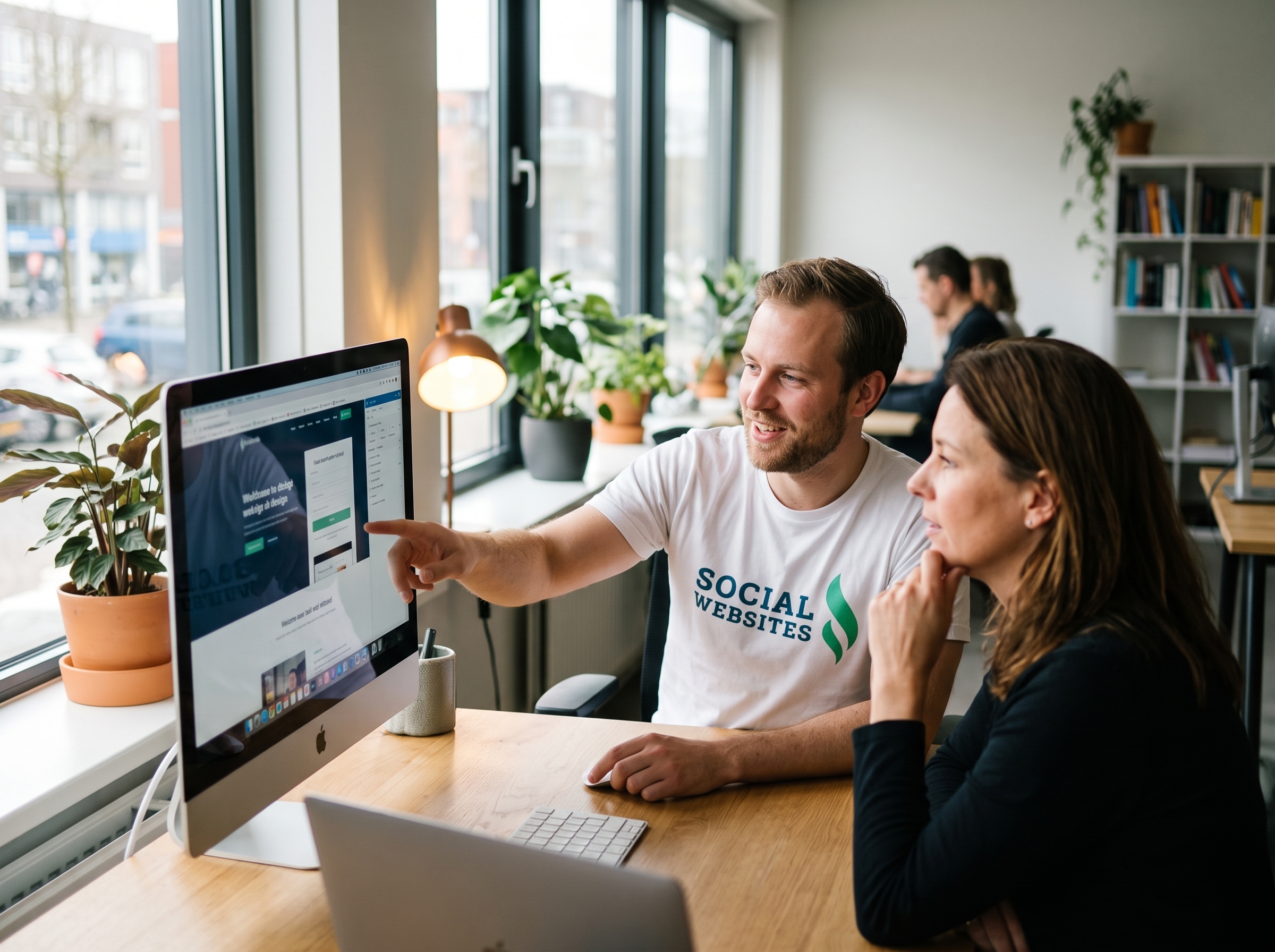 Een webdesigner van Social Website in overleg met een klant.